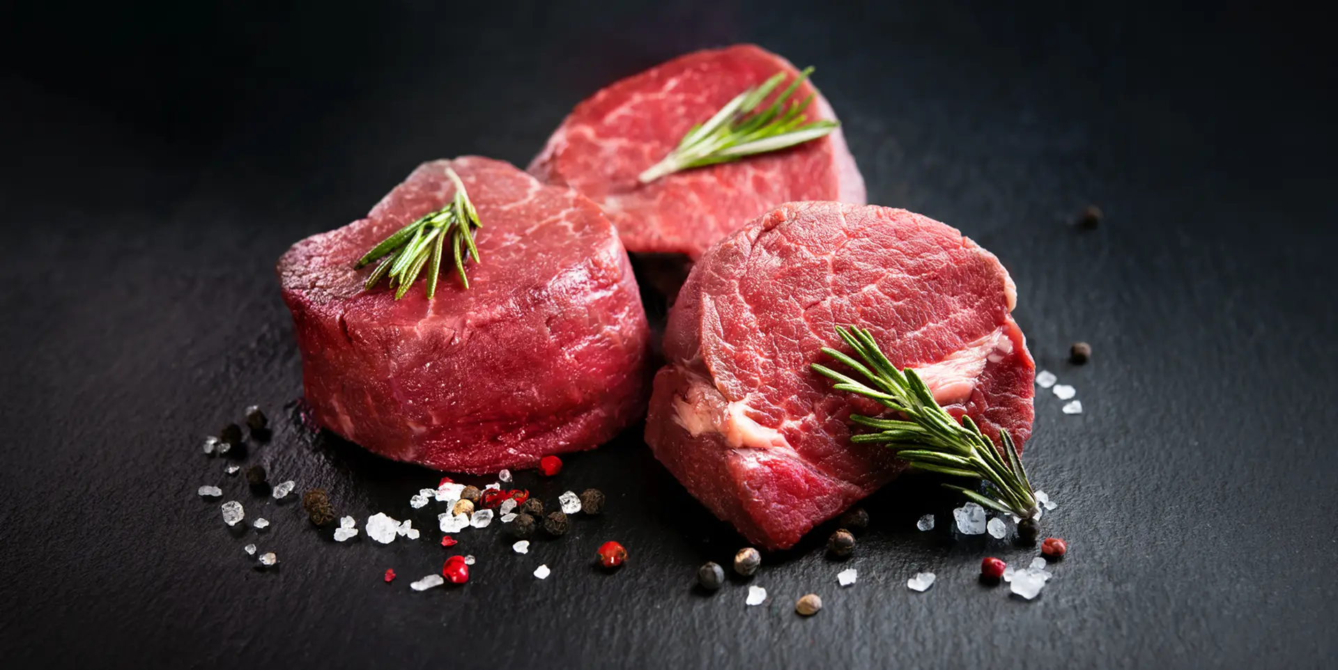 The All-Natural Ontario Beef Tenderloin Filet Steak from Beverly Creek is the pinnacle of tenderness and refined taste. Meat is rich, tender and presented on a dark slate background with peppercorns.